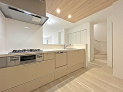 【Kitchen】
温かみのある木目調の天井と明るい色合いの建具が調和し、心地よい空間が広がります。生活空間へと続く階段は、穏やかな時を刻むような落ち着きを感じさせます。

